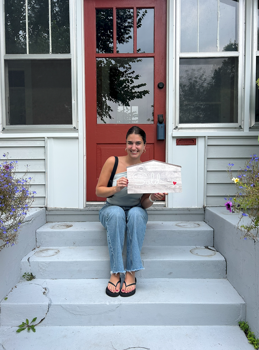 Homebuyer in front of new house.